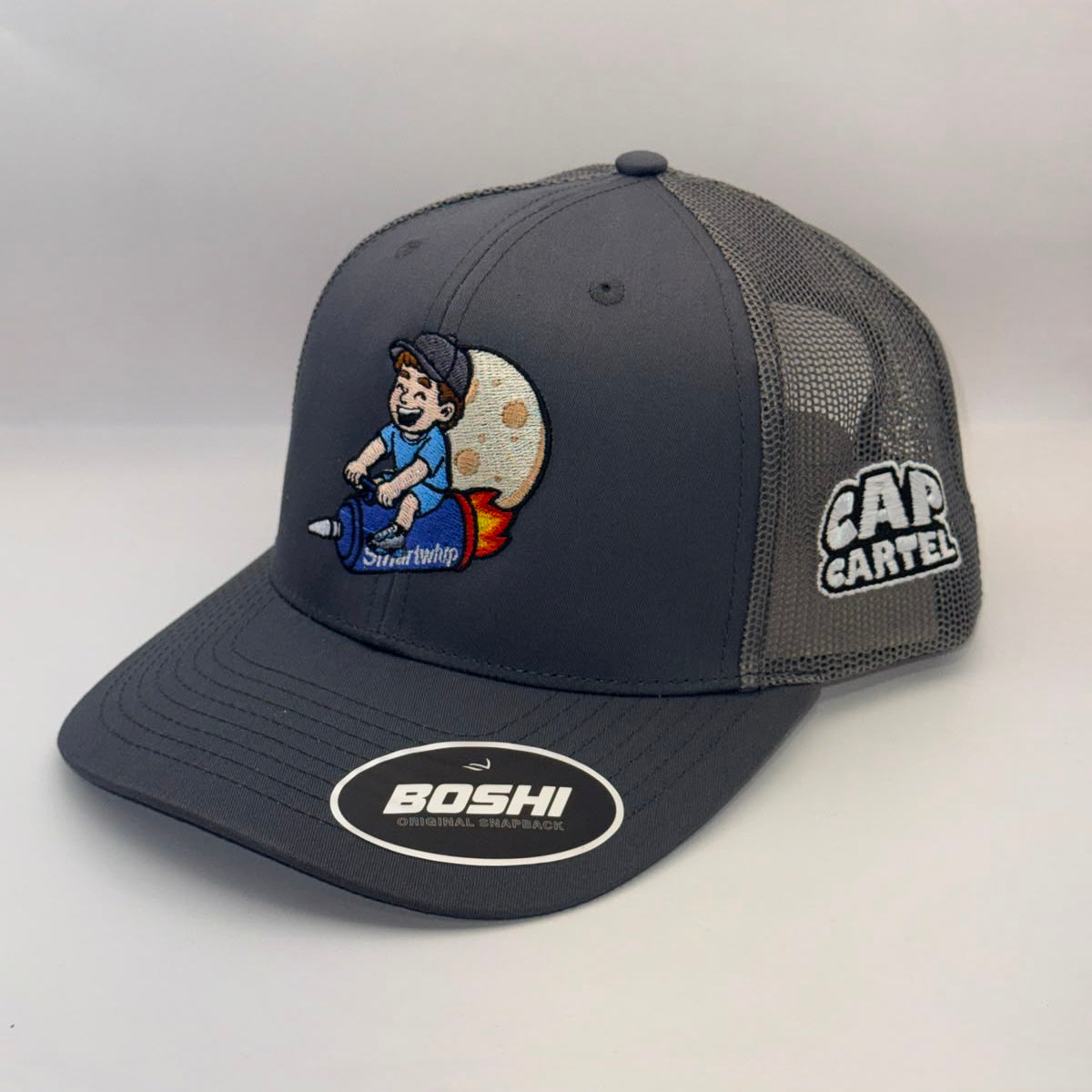 A dark gray and black mesh-back trucker hat with a cartoon graphic of a person sitting on a moon on the front panel, a 'CAR GARFEL' logo on the side mesh, and a 'BOSHI' sticker on the brim.
